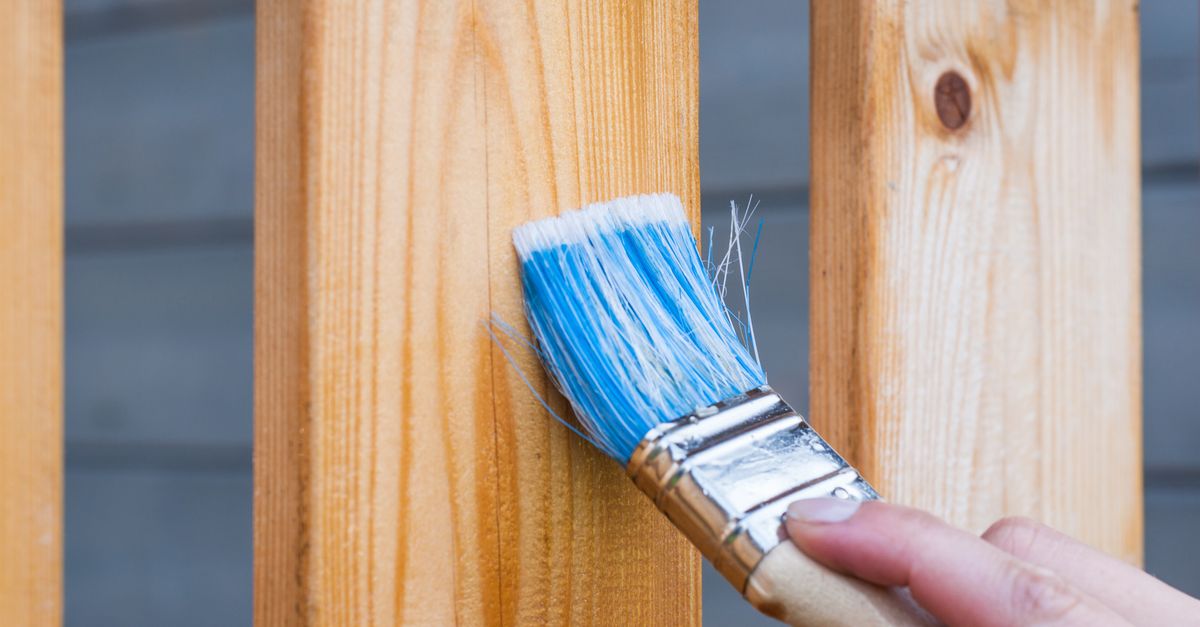 Application d'un saturateur bois au pinceau sur une terrasse en bois extérieur