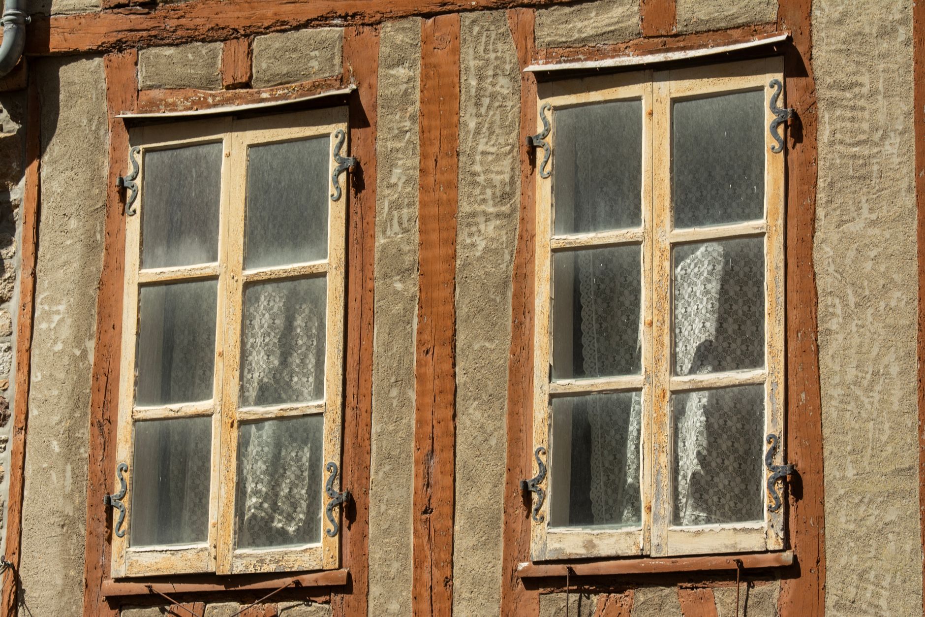 Fenêtre à deux vantaux en bois peint blanc avec double vitrage dans une maison ancienne